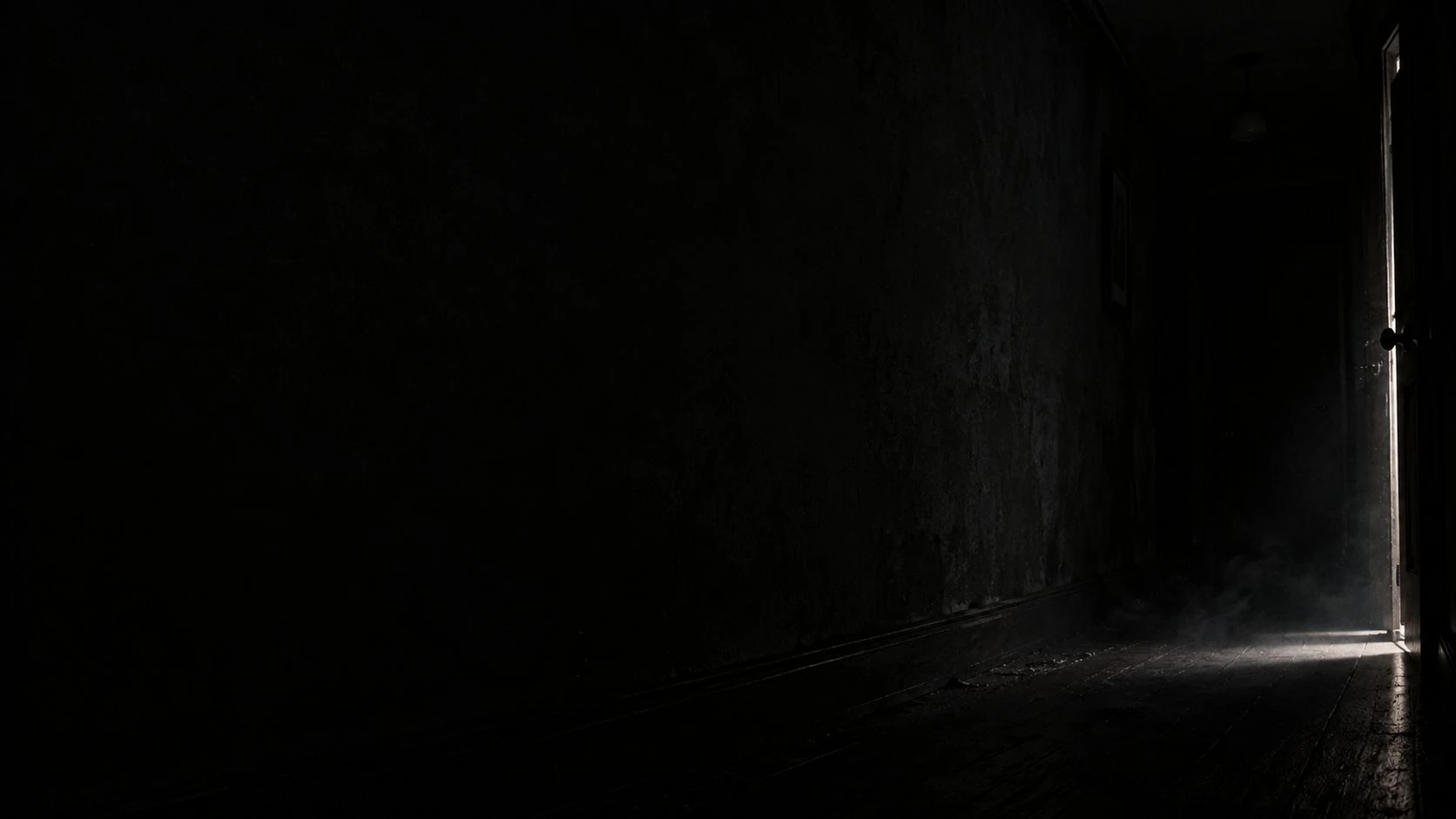 A thread of light beneath a dark doorway